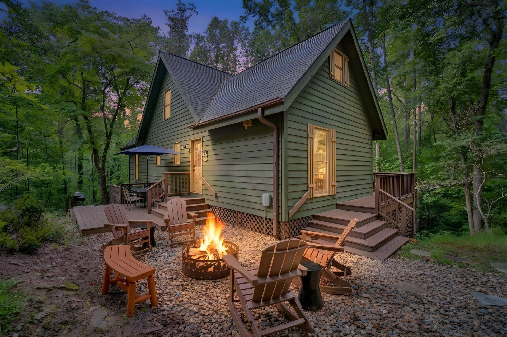 Rainbow's End cabin at twilight with a glowing fire pit on the stone patio
